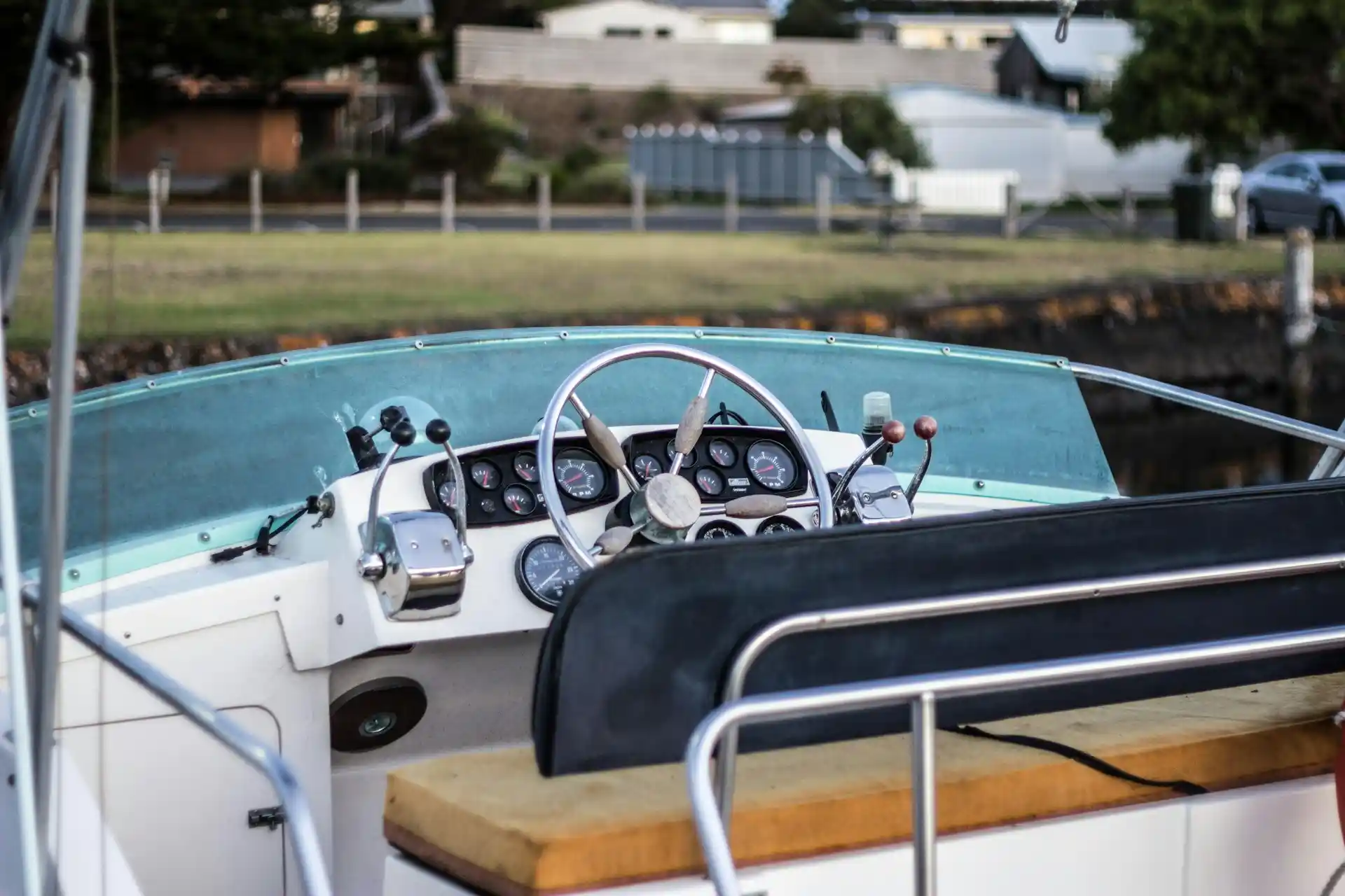 The steering wheel and control panel of a boat's cockpit, hinting at the mechanical components that answer the question, do houseboats have motors?