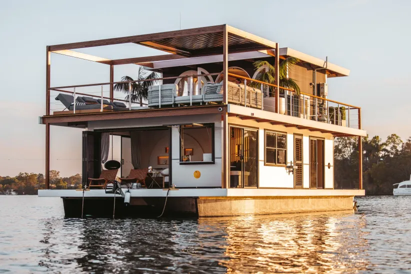 Modern floating home on water showcasing lifestyle questions around houseboat addresses legal and residency options.